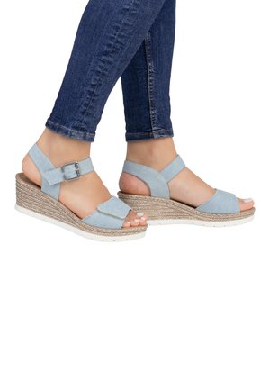 Light blue wedge sandals with a fabric upper, open toe, and ankle strap featuring a metal buckle. Textured jute-woven midsole and white outsole.