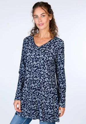 Marineblaue Langarm-Tunika mit V-Ausschnitt, ausgestattet mit einem weißen Blumen- und Blattmuster. Der Stoff hat eine glatte Textur und ist für eine entspannte Passform konzipiert.