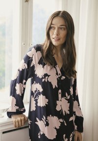 Rochie cu mânecă lungă de culoare bleumarin, decorat�ă cu modele florale mari în nuanțe de roz, având o deschidere cu nasturi și o croială lejeră. Material moale cu textură netedă.