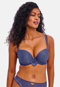 Námořnická modrá vycpaná podprsenka s květinovými krajkovými detaily, vroubkovanými okraji a nastavitelnými ramínky; hladký povrch s jemným leskem.