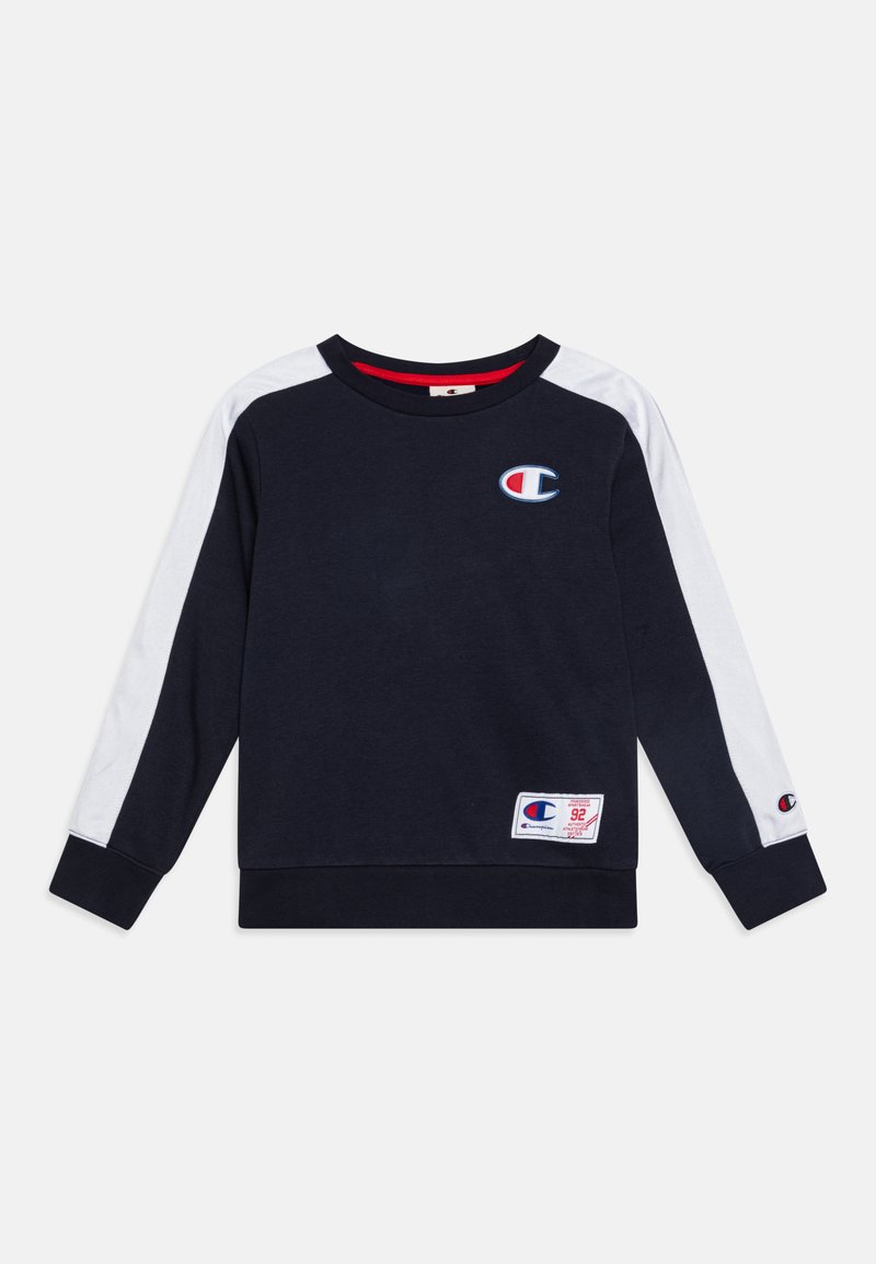 Ναυτικό φούτερ με λευκές πάνες στους ώμους, στρογγυλή λαιμόκοψη και ελαστικές μανσέτες. Έχει ένα μικρό λογότυπο και μια υφασμένη ετικέτα στο στρίφωμα.