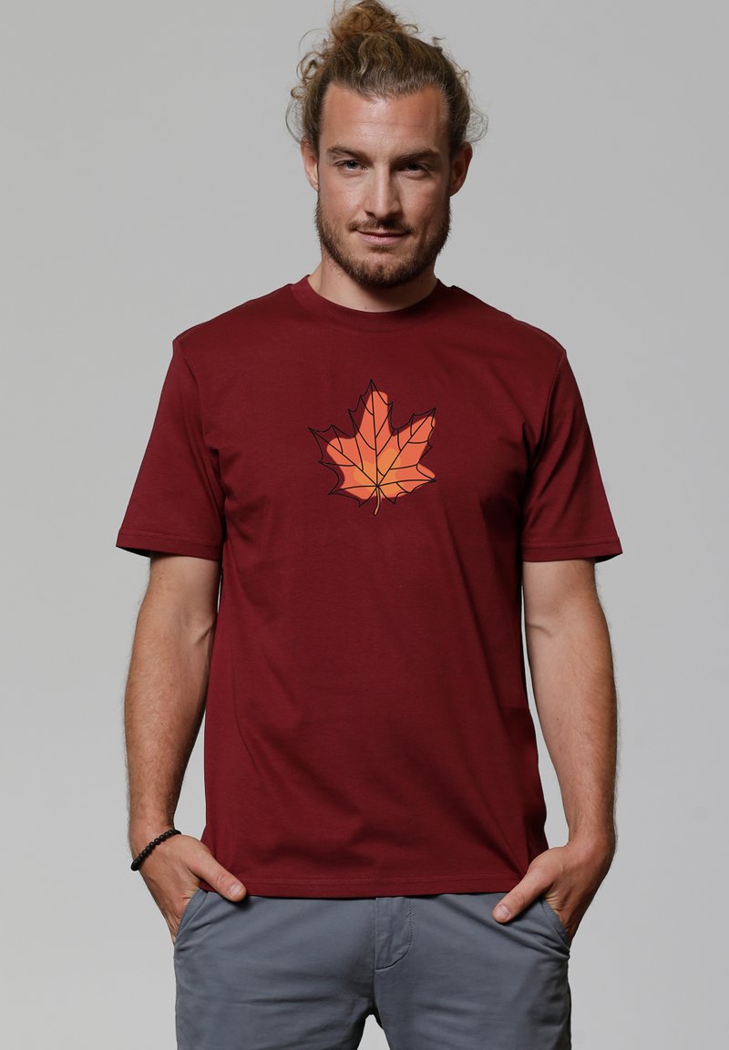 Bordeaux t-shirt met een geometrische oranje esdoornbladprint op de voorkant. Korte mouwen en ronde halslijn, vervaardigd uit zachte materialen.
