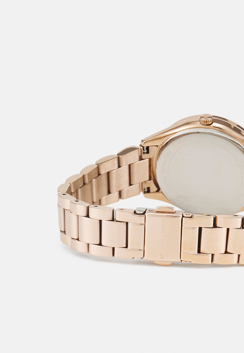 Złoty zegarek rodowany z bransoletą w formie ogniw. Posiada okrągłą tarczę, widoczną koronkę oraz zapięcie na zatrzask. Tył wykonany ze stali nierdzewnej.