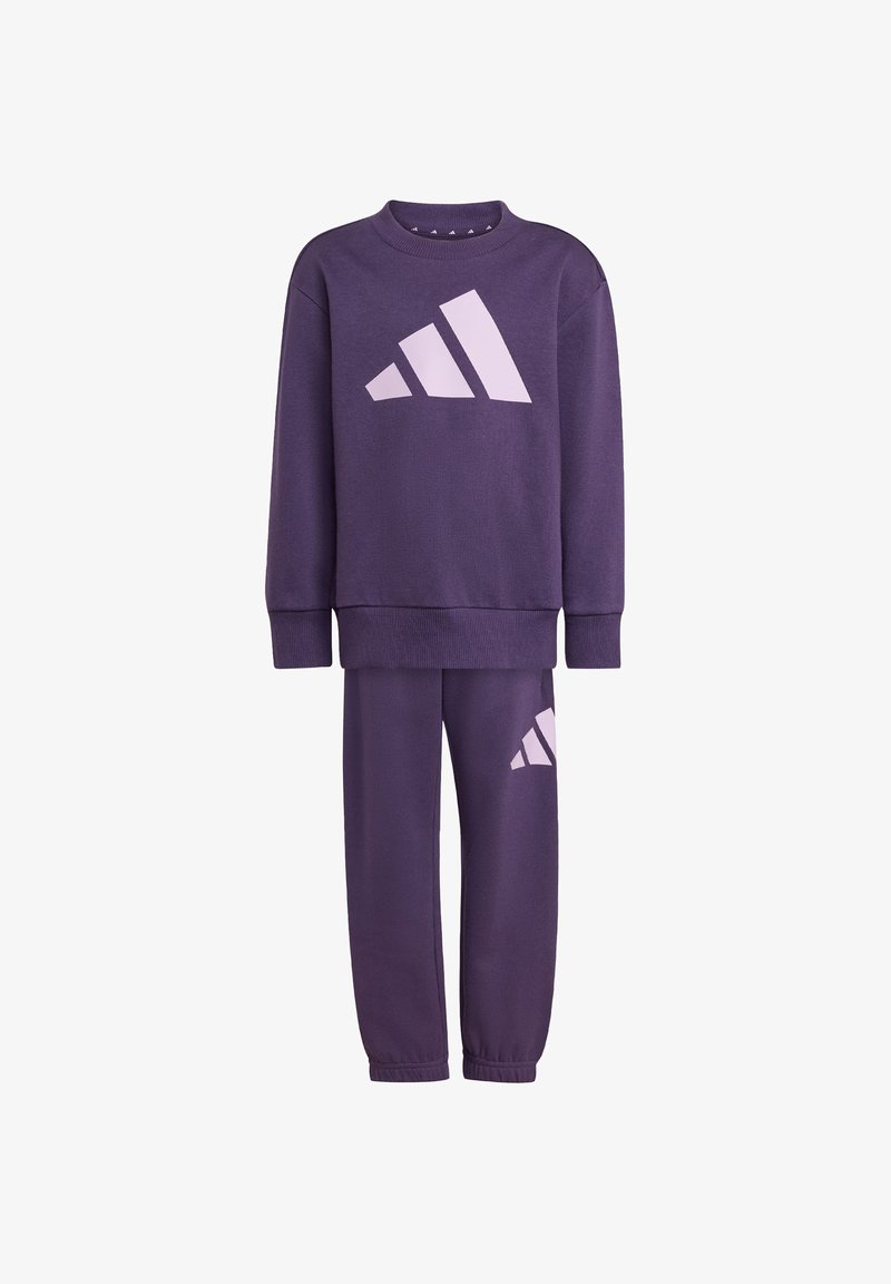 Ensemble sweat à capuche et pantalon violet, en tissu doux, arborant un grand logo Adidas rose à l'avant et sur le côté. Poignets et encolure côtelés.