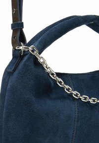 Marineblaue Wildlederhandtasche mit glatter Textur, verziert mit einer silbernen Kettenakzentuierung und einem Leder-Riemen. Strukturierte Form mit dezenten Steppnähten.