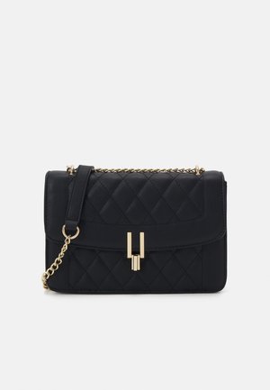 Quiltet sort læder håndtaske med en guldfarvet kædestrop, der har en fold-over klap og en geometrisk låsdetalje.