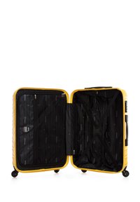 Tuhý žlutý kufr na čtyřech kolečkách, zipové uzávěry, černě podšívkový interiér s popruhy a malou zipovou kapsou.