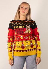 Strickpullover in Schwarz, Rot und Gelb mit festlichen Bier-Themen-Mustern, die Hunde, Brezeln und Nussknacker-Designs zeigen. Mit gerippten Bündchen und Saum.