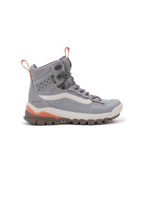 Botte de randonnée montante grise avec accents orange, semelle marron robuste, devant à lacets, et matériau imperméable Gore-Tex.