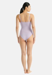 Fialový jednodílný plavky s nastavitelnými ramínky, nízkým výstřihem na zádech a hladkým povrchem s vysokým vykrojením nohavic.