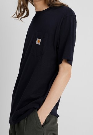 Korte mouw T-shirt navyblauw, gemaakt van katoen, met een borstzakje voorzien van een vierkante oranje label, losse pasvorm, zachte textuur.
