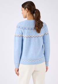 Maglione azzurro chiaro in maglia realizzato in morbida lana, con un corpetto decorato in crema, beige e colori tenui, presenta una vestibilità rilassata e maniche lunghe.