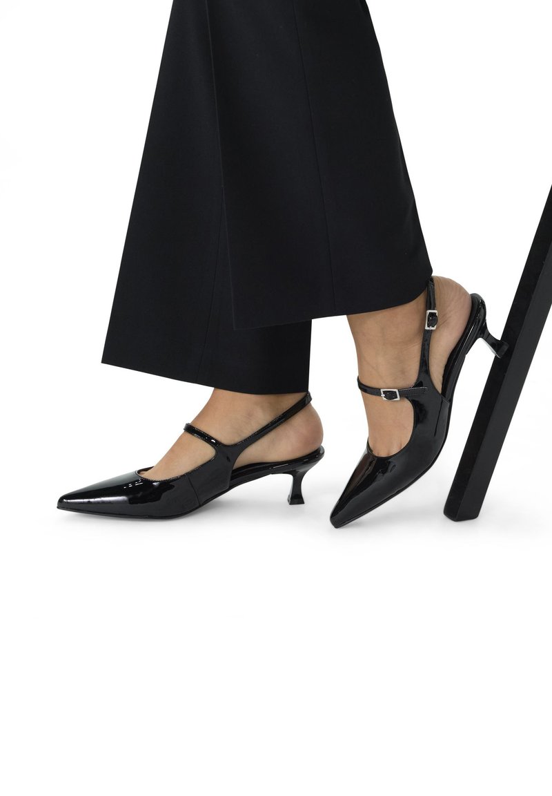 Zwarte gepatenteerde leren slingback hakken met een spitse neus, verstelbare band en een smalle, gemiddelde hak. Glad, glanzend oppervlak.