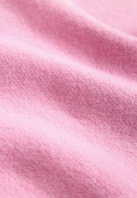 Pehmeä vaaleanpunainen kangas, jossa on hieno, tekstuuri pinta, jossa on lempeitä poimuja ja hieman karhea ulkonäkö. Sopii vaatteisiin tai verhoiluun.