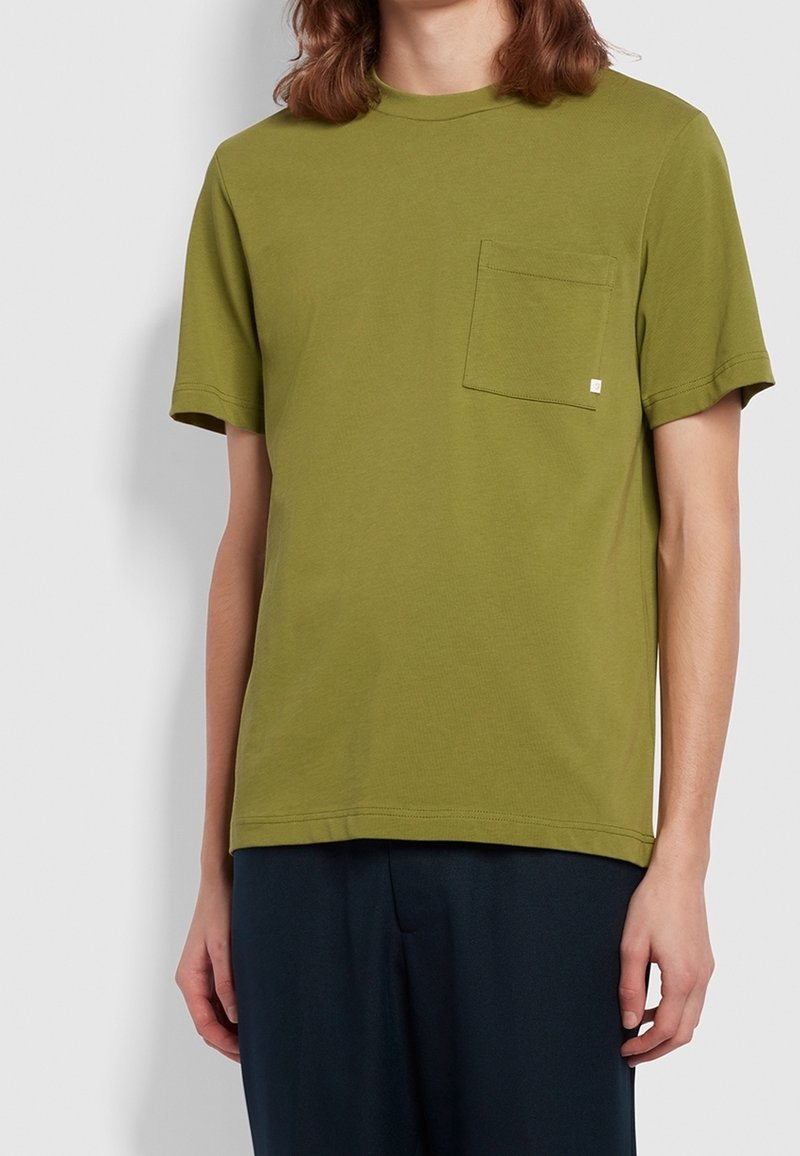 T-shirt en coton vert olive avec un col rond, des manches courtes et une poche sur la poitrine gauche. Design simple avec une coupe régulière et un minimum de détails.