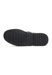 Zwarte schoenzool met een gestructureerd, geribbeld patroon. Heeft een gladde, ronde neus en een platte, flexibele basis voor comfort.