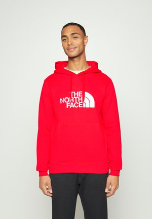 Sweatshirt com capuz vermelho feito de mistura de algodão, com o logótipo branco "THE NORTH FACE", apresentando um bolso canguru e punhos canelados.