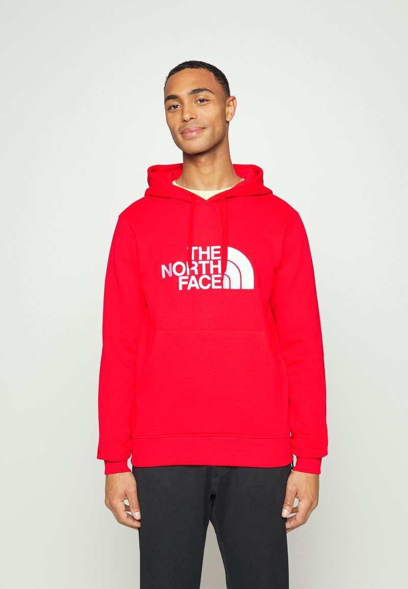 Sweatshirt com capuz vermelho feito de mistura de algodão, com o logótipo branco "THE NORTH FACE", apresentando um bolso canguru e punhos canelados.