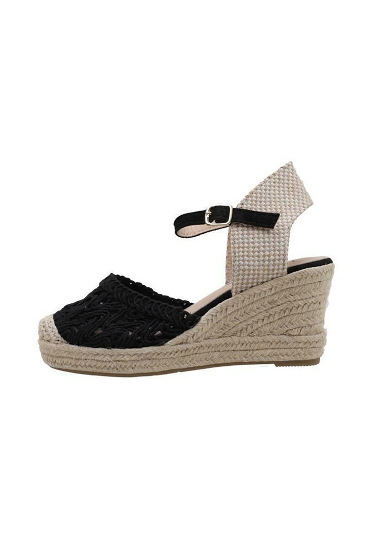 Sandale compensée en tissu noir tissé avec une semelle en jute tressé, dotée d'une sangle beige et d'une boucle réglable à la cheville.