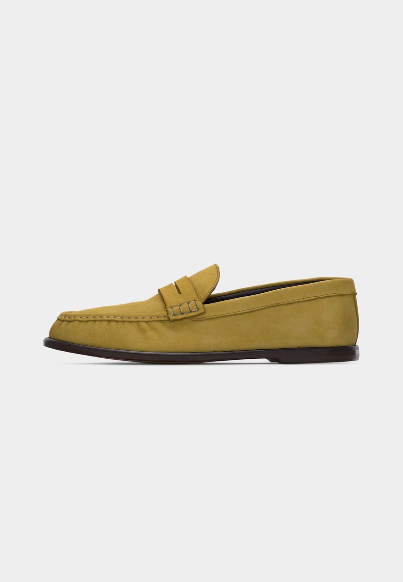Mocassin pour homme en daim jaune moutarde avec lanière à penny et semelle basse marron foncé, présenté en profil latéral sur fond blanc.