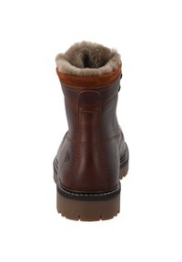 Bruine leren enkellaars met een zachte beige nepbont voering, suède accenten bij de kraag en een duurzame rubberen zool met gripdetails.