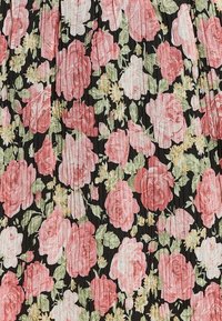 Černá tkanina s plisováním, která má velké růžové růže a malé žluté květiny, vytvářející květinový vzor se zelenými listy po celém povrchu.