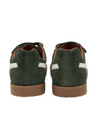 Zapatillas de ante verde con suela de goma marrón, acentos laterales blancos y un interior acolchado. El diseño es estilizado sin logotipos visibles.