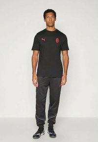 Puma ACM KING ANTHEM  - Tracksuit bottoms - black red