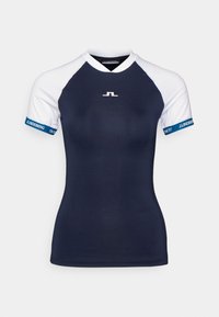 Mörkblå sport-t-shirt med vita raglanärmar, logga framtill och blå accenter vid ärmsluten. Tillverkad av ett slätt, stretchigt material.