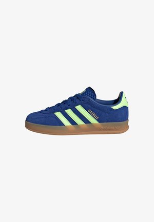 Blauer Adidas Gazelle Wildledersneaker mit hellgrünen Streifen, Gummisohle und „Gazelle“-Schriftzug an der Seite.