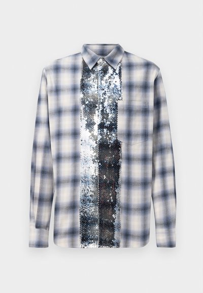 Pikendusega sinine ja valge ruuduline särk, mille keskosas on vertikaalne paneel läikivate hõbedaste sädelevate litritega, mis ulatub kaelusest hemmini.