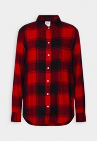 Chemise en flanelle à carreaux rouge et noir avec manches longues, fermeture boutonnée à l'avant, col et poche poitrine unique. Texture douce et ourlet arrondi.