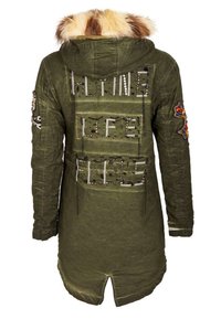 Parka vert olive avec capuche bordée de fourrure, texte orné de sequins "ONLINE LIFE FILES" au dos, et patchs colorés ornés de bijoux sur les manches.