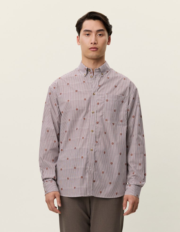 Camisa abotonada a rayas blancas y burdeos con pequeños patrones florales marrones. Manga larga, cuello estándar y detalle de bolsillo en el pecho.