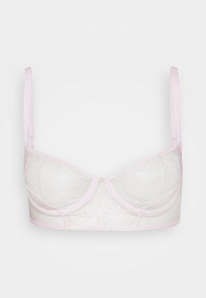 Reggiseno rosa chiaro con coppe trasparenti ricamate e spalline regolabili su uno sfondo bianco semplice.