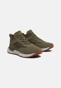 Zapatillas deportivas de color verde oliva con parte superior de malla y tejido, que cuentan con una suela acolchada, cordones planos y una suela de goma.