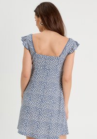 Blue floral dress with white patterns, short ruffled sleeves, square back, and a loose fit, made from lightweight fabric.