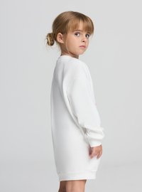 Vestito felpa bianco con maniche lunghe e polsini a costine, caratterizzato da una scollatura rotonda e una vestibilità comoda, progettato per bambini.