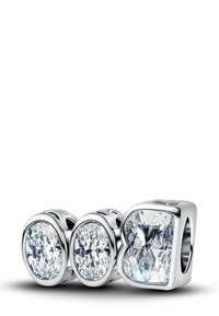 Tre perline di charm in argento con gemme trasparenti e sfaccettate. Le forme includono ovale e quadrata. Ogni perla presenta intagli decorativi sui lati.