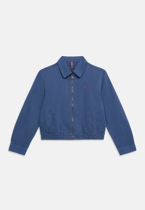 Blue zip-up jacket with collar, two front pockets, elastic waistband, and small red embroidered logo on the left chest.