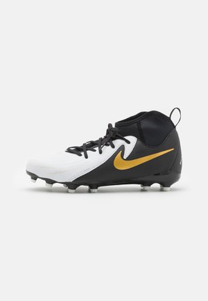 Botas de fútbol con un diseño en blanco y negro. Presentan un logo de Nike dorado, un upper texturizado y tacos moldeados para tracción.