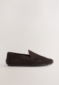 Mocassin en daim marron avec une tige texturée, des détails cousus et une semelle en caoutchouc flexible dotée de petites bandes circulaires pour l'adhérence.