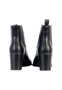 Bottines en cuir noir avec des panneaux élastiques sur les côtés, un bout arrondi, un talon bloc de 7 cm et des détails de couture visibles sur les côtés.