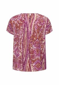 Blouse à manches courtes présentant un motif floral et géométrique en rose, violet et crème, avec une ouverture en forme de clé au dos. Le tissu semble léger.