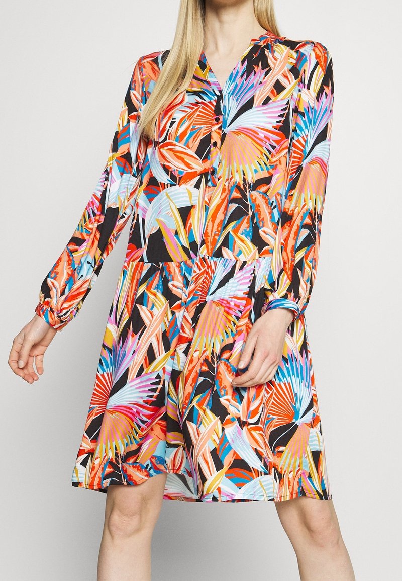 Vestido floral con patrones vibrantes en rosa, azul, naranja y negro, con mangas largas, un escote en V con botones y una falda acampanada.