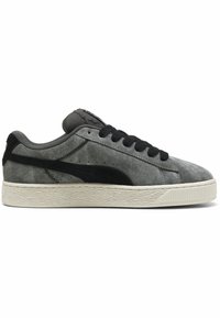 Sneaker in suede grigio con accenti neri, texture liscia, chiusura con lacci e suola in gomma rigata. Presenta un logo sulla linguetta e sul lato.