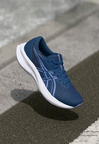 Nαυτικές αθλητικές κάλτσες με υφασμένη επάνω, ενισχυμένη μύτη και αφρώδη σόλα. Διαθέτουν ανοιχτό μωβ λεπτομέρειες και μοντέρνο, ρέουσα σχεδίαση.