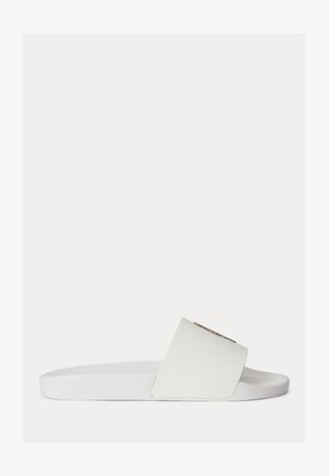 Papuc alb cu talpă joasă, bretea largă și talpă interioară texturată, văzut din profil pe un fundal simplu.