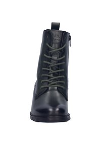 Botas de tobillo de cuero negro con cordones verdes, cremallera frontal, punta redondeada y acabado suave. Presenta un pequeño tirador en la parte trasera.