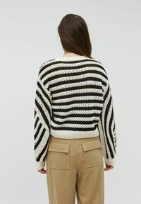 Černo-bíle pruhovaný pletený svetr s volným střihem, žebrovanými manžetami a spodním lemem. Rukávy do loktů s detailním texturovaným vzorem.